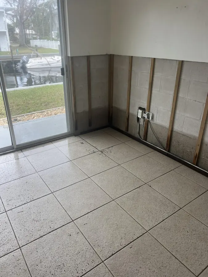 Flood-cut block wall beside a sliding glass door facing a Punta Gorda canal